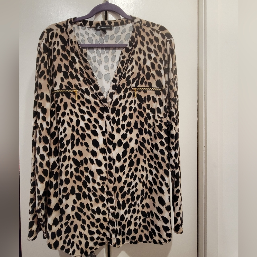 Ladies tunic blouse with decorative zipper pockets in front. 95% poly 5% spandex